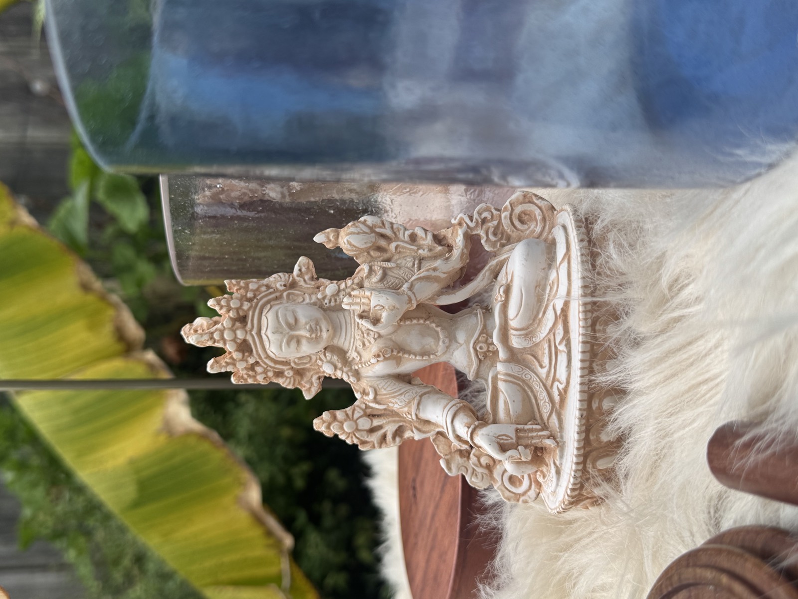 White Tara statue beside a crystal singing bowl